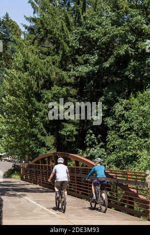 Ein junges Paar fährt mit dem Fahrrad auf einem Trail in der Nähe von Troutdale, Oregon. Stockfoto