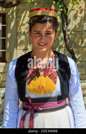 Junges Mädchen mit einem traditionellen kroatischen roten Filzhut, weißem Hemd und schwarz gestickter Weste in Cilipi, Kroatien Stockfoto