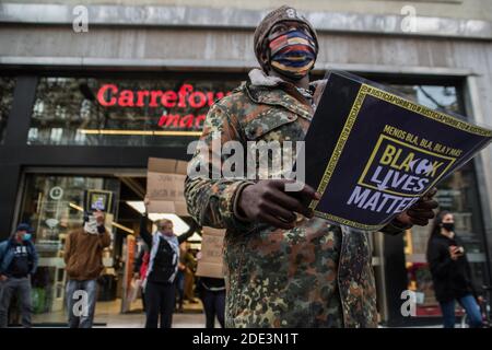 Ein Protestant mit einem Plakat, auf dem steht: "Black Lives Matter" während der Demonstration der Tod des 40-jährigen João Alberto Silveira, eines schwarzen Mannes, der am 19. November in Porto Alegre, Brasilien, von Carrefour Vigilanten brutal geschlagen wurde, hat eine Protestwelle in mehreren brasilianischen Städten ausgelöst. In Barcelona machen antirassistische Gruppen vor dem Carrefour auf Las Ramblas einen Akt der Ablehnung. Stockfoto