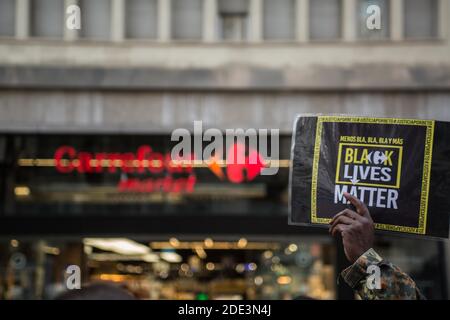 Ein Protestant mit einem Plakat, auf dem steht: "Black Lives Matter" während der Demonstration der Tod des 40-jährigen João Alberto Silveira, eines schwarzen Mannes, der am 19. November in Porto Alegre, Brasilien, von Carrefour Vigilanten brutal geschlagen wurde, hat eine Protestwelle in mehreren brasilianischen Städten ausgelöst. In Barcelona machen antirassistische Gruppen vor dem Carrefour auf Las Ramblas einen Akt der Ablehnung. Stockfoto