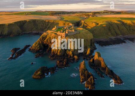 Ein Wintersonnenaufgang über Dunnottar Castle auf einer felsigen Landzunge in der Nähe von Stonehaven, Aberdeenshire in Schottland Stockfoto