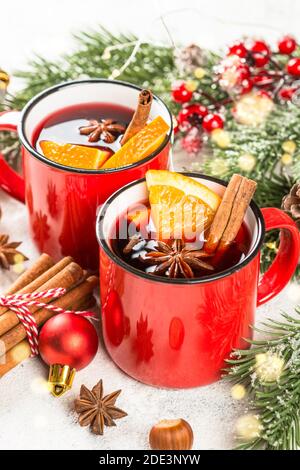 Glühwein in roten Tassen mit weihnachtsschmuck. Stockfoto