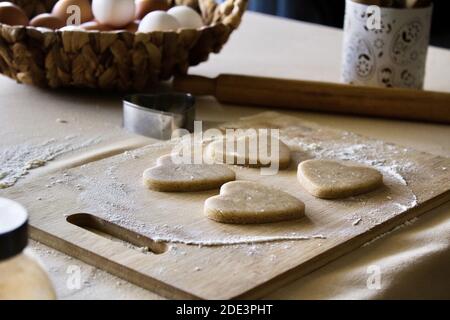 Herzförmiger Plätzchenteig auf dem Tisch Stockfoto