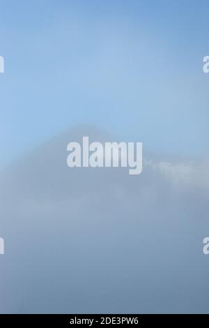 Langsam driftet Nebel in den Bergen fort Stockfoto