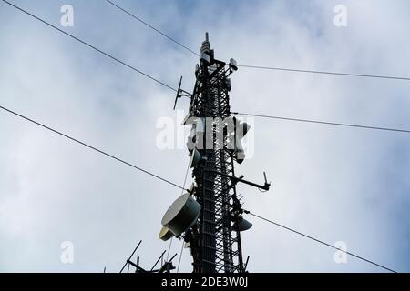 Großer Mobilfunkturm mit Arrays, Antennen und Schalen für mobile Verbindungen sowie 4G- und 5G-Internet. Stockfoto