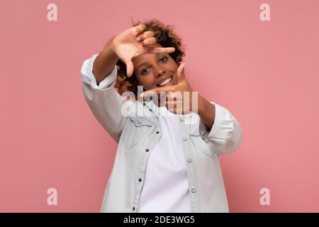 Glücklich gemischt Rennen Frau Rahmen Foto isoliert auf rosa Hintergrund. Kreatives Fotografiekonzept. Stockfoto