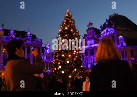 Brüssel, Belgien. November 2020. Ein Mann fotografiert den mit einem Weihnachtsbaum geschmückten Grand Place in Brüssel, Belgien, am 28. November 2020. Der Weihnachtsbaum am Grand Place von Brüssel wurde in diesem Jahr mit dem Thema "neu" dekoriert. Quelle: Zheng Huansong/Xinhua/Alamy Live News Stockfoto