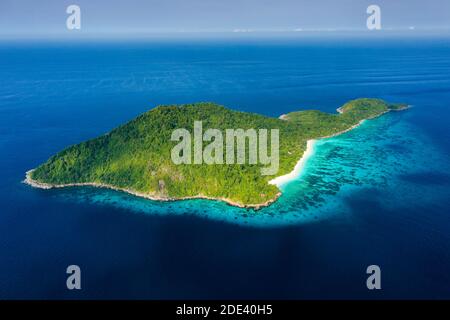 Luftaufnahme eines einsamen Strandes auf einer zerklüfteten tropischen Insel, umgeben von Korallenriff (Koh Tachai). Stockfoto
