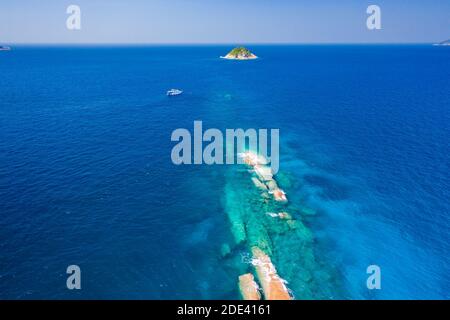 Luftaufnahme eines Tauchbootes in der Nähe eines schmalen tropischen Korallenriffs und einer kleinen Insel in der Andamanensee. Stockfoto