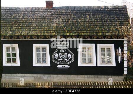 Suceava County, Rumänien. Traditionelles Haus mit Holzgefliesten Dach und Zierleisten auf der Außenseite. Stockfoto