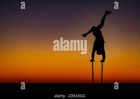 La JOLLA, KALIFORNIEN. 27. November 2020. Ein Outddor Turner macht einen Handstand mit dem Sonnenuntergang hinter ihm am Torrey Pines Gliderport oberhalb von Black's Stockfoto