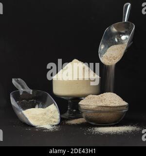 In Glasschalen Kokosmehl und Psyllium werden die Kugeln mit Schüttgütern gefüllt. Kohlenhydratarme Backzutaten. Keto Shop Konzept. Stockfoto