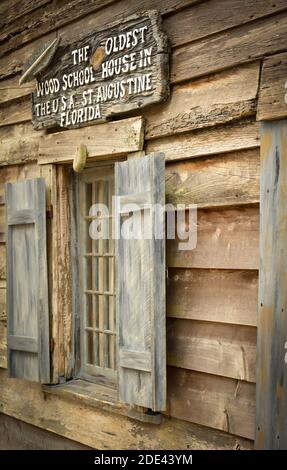 Eine Nahaufnahme der Beschilderung und Fenster eines restaurierten Gebäudes verkündet, dass es das älteste Holzschulhaus in den USA ist, St. Augustine, FL Stockfoto