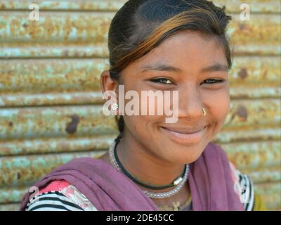 Fröhliche ziemlich schelmisch indischen Gujarati Teenager-Mädchen aus Kutch mit Wangendippen und gefärbten Strang von Haaren lächelt für die Kamera. Stockfoto