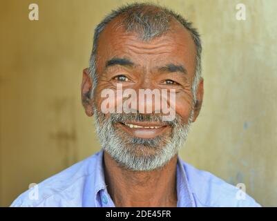 Glücklich positive mittleren Alters indischen Gujarati Mann mit kurzen Haaren lächelt für die Kamera. Stockfoto