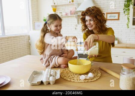 Mutter und Tochter bereiten in der Küche gemeinsam einen Kuchen zu Stockfoto