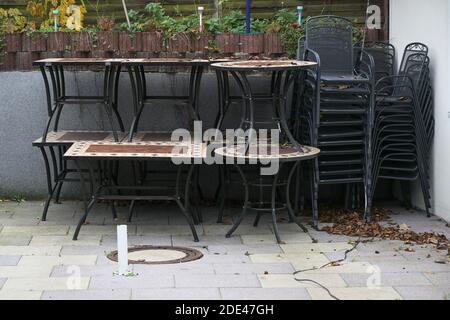Gestapelte Tische und Stühle auf der Restaurantterrasse während des Schließens Aufgrund einer Coronavirus-Pandemie Stockfoto