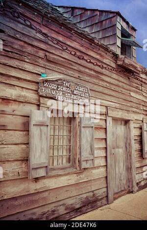 Ein Schild, das über dem Fenster des primitiven Gebäudes angebracht ist, verkündet, das älteste hölzerne Schulhaus in den USA zu sein und Touristen in St. Augustine, FL anzuziehen Stockfoto