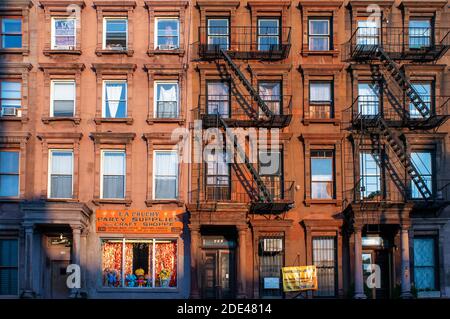 Feuerleitern auf Wohnhäuser Wohnung im Viertel von Harlem, New York City. Stockfoto