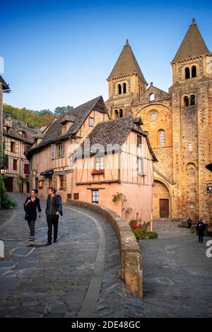 Das kleine mittelalterliche Dorf Conques in Frankreich. Es zeigt den Besuchern seine Abtei-Kirche und geclusterte Häuser gekrönt von Schieferdächern. Kreuzung der engen Straße Stockfoto