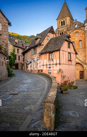 Das kleine mittelalterliche Dorf Conques in Frankreich. Es zeigt den Besuchern seine Abtei-Kirche und geclusterte Häuser gekrönt von Schieferdächern. Kreuzung der engen Straße Stockfoto