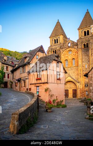 Das kleine mittelalterliche Dorf Conques in Frankreich. Es zeigt den Besuchern seine Abtei-Kirche und geclusterte Häuser gekrönt von Schieferdächern. Kreuzung der engen Straße Stockfoto