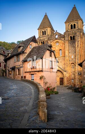 Das kleine mittelalterliche Dorf Conques in Frankreich. Es zeigt den Besuchern seine Abtei-Kirche und geclusterte Häuser gekrönt von Schieferdächern. Kreuzung der engen Straße Stockfoto