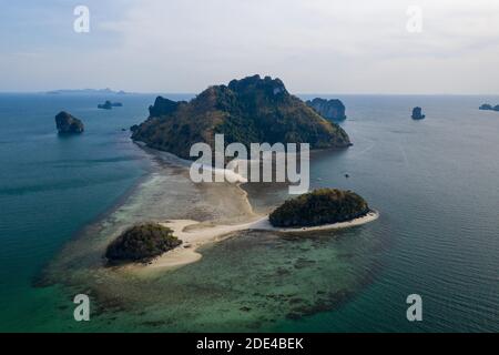 Luftaufnahme, tropische Insel bei Sonnenuntergang mit vorgelagertem Riff und zwei kleineren Inseln, Koh Po da NOK Insel, Krabi Provinz, Thailand Stockfoto