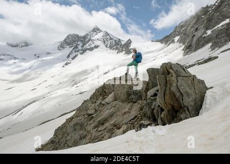 Schneefeld, Wanderer steht auf einem Stein, Abstieg vom Schönblichler Horn, Waxeggkees Gletscher, Weg vom Furtschaglhaus zur Berliner Huette, hoch Stockfoto