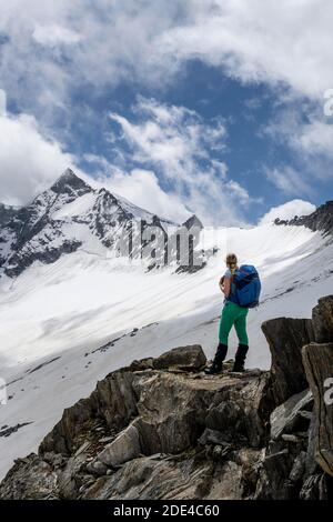 Schneefeld, Wanderer steht auf einem Stein, Abstieg vom Schönblichler Horn, Waxeggkees Gletscher, Weg vom Furtschaglhaus zur Berliner Huette, hoch Stockfoto