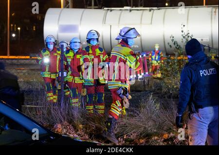 Itzehoe, Deutschland. November 2020. Feuerwehrleute laufen mit einer Leiter über die Gleise in der Nähe des Unfallort. Zwei Menschen sind auf einen Wagen in der Itzehoe Station geklettert und wurden durch einen Stromschlag von der Oberleitung getötet. Eine andere Person sei leicht verletzt worden, sagte ein Sprecher der Bundespolizei am Sonntagabend. Quelle: Jonas Walzberg/dpa - ACHTUNG: Der Schriftzug auf dem Güterwagen wurde aus rechtlichen Gründen verpixelt/dpa/Alamy Live News Stockfoto