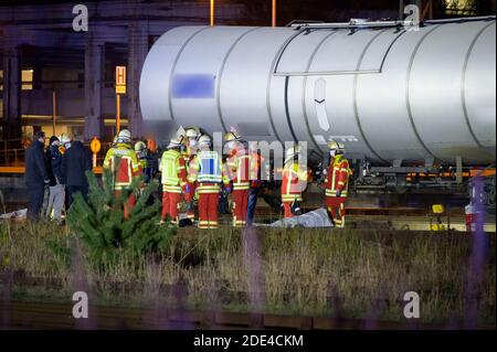 Itzehoe, Deutschland. November 2020. Rettungskräfte und Ermittler stehen neben den bedeckten Leichen auf dem Tanklager. Zwei Menschen sind auf einen Wagen in der Itzehoe-Station geklettert und durch einen Stromschlag von der Oberleitung getötet worden. Eine andere Person sei leicht verletzt worden, sagte ein Sprecher der Bundespolizei am Sonntagabend. Quelle: Jonas Walzberg/dpa - ACHTUNG: Der Schriftzug auf dem Güterwagen wurde aus rechtlichen Gründen verpixelt/dpa/Alamy Live News Stockfoto