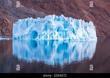 Eisberg vor Felsen im Fjord, Kaiser-Franz-Joseph-Fjord, Ostküste Grönland, Dänemark Stockfoto