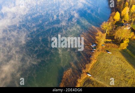 Nebelschwaden am Irrsee mit Fischerbooten im Schilfgürtel, Bodennebel, von oben, Drohnenaufnahme, Luftaufnahme, Zell am Moos, Salzkammergut, Obere Stockfoto