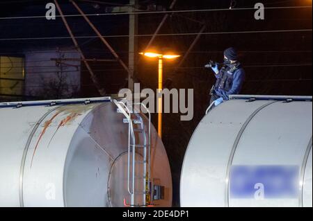 Itzehoe, Deutschland. November 2020. Ein Polizist fotografiert Spuren auf dem Tankwagen am Unfallort. Zwei Menschen sind auf einen Wagen in der Itzehoe Station geklettert und wurden durch einen Stromschlag von der Oberleitung getötet. Eine andere Person sei leicht verletzt worden, sagte ein Sprecher der Bundespolizei am Sonntagabend. Quelle: Jonas Walzberg/dpa - ACHTUNG: Der Schriftzug und die Nummer auf dem Güterwagen wurden aus rechtlichen Gründen verpixelt, Blutspuren sind zu sehen./dpa/Alamy Live News Stockfoto