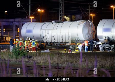 Itzehoe, Deutschland. November 2020. Rettungskräfte und Ermittler stehen neben den bedeckten Leichen auf dem Tanklager. Zwei Menschen sind auf einen Wagen in der Itzehoe-Station geklettert und durch einen Stromschlag von der Oberleitung getötet worden. Eine andere Person sei leicht verletzt worden, sagte ein Sprecher der Bundespolizei am Sonntagabend. Quelle: Jonas Walzberg/dpa - ACHTUNG: Der Schriftzug und die Nummer auf dem Güterwagen wurden aus rechtlichen Gründen verpixelt, Blutspuren sind zu sehen./dpa/Alamy Live News Stockfoto