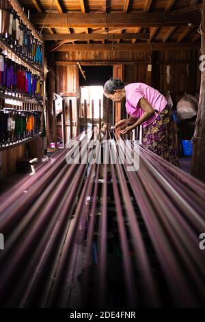 Frau zieht bunte Fäden auf Webstuhl, Lake Inle, Myanmar Stockfoto