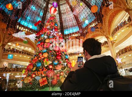 (201129) -- PARIS, 29. November 2020 (Xinhua) -- EIN Mann fotografiert einen riesigen Weihnachtsbaum im Kaufhaus Lafayette während seines ersten Eröffnungstages in Paris, Frankreich, am 28. November 2020. Am Samstag startete Frankreich die erste Phase seiner dreistufigen Wiedereröffnungsstrategie. Alle nicht-wesentlichen Geschäfte nahmen ihre Aktivitäten unter strengem Gesundheitsprotokoll wieder auf: Bereitstellung von mindestens 8 Quadratmetern Werkstattfläche für jeden Kunden, einseitige Zirkulation und ausreichende Belüftung. Die COVID-19 Hospitalisierungen in Frankreich gingen am Samstag weiter zurück, als das Land einen dreistufigen Lockdown-Ausgang begann. (Xinhua/Gao Jin Stockfoto