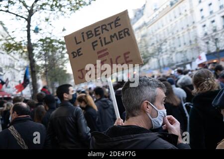 Paris, Frankreich. November 2020. Ein Protestant mit Gesichtsmaske hält ein Plakat mit der Aufdruck Freiheit zu Filmen = Gerechtigkeit während der Demonstration.Tausende von Demonstranten gingen auf die Straße in Paris, Frankreich, um gegen das umstrittene Sicherheitsgesetz zu demonstrieren, das den Austausch von Bildern von Polizisten einschränken würde. Kredit: SOPA Images Limited/Alamy Live Nachrichten Stockfoto