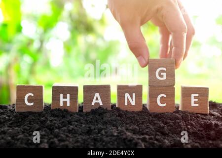 Chance auf Veränderung, neue Chance, Optimismus und Karriereentwicklung Konzept. Männliche Hand ändern oder Spiegeln Wort Chance, Holzblöcke Würfel in natu ändern Stockfoto