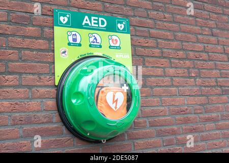 Automatisierter externer Defibrillator (AED) an einer Ziegelwand. Tragbares elektronisches erste-Hilfe-Gerät zur Wiederherstellung des Herzrhythmus. Stockfoto