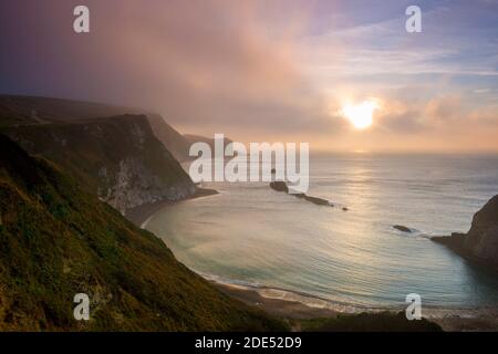 Durdle Door, Dorset, Großbritannien. November 2020. Nebliger Sonnenaufgang an der Over man O'war Bay am Durdle Door in Dorset. Bild: Graham Hunt/Alamy Live News Stockfoto