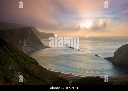 Durdle Door, Dorset, Großbritannien. November 2020. Nebliger Sonnenaufgang an der Over man O'war Bay am Durdle Door in Dorset. Bild: Graham Hunt/Alamy Live News Stockfoto