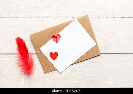Grußkarte Vorlage mit Bastelpapier Umschlag und leuchtend roten Herzen und Feder. Karte Text Design für Social Media Blogs Stockfoto