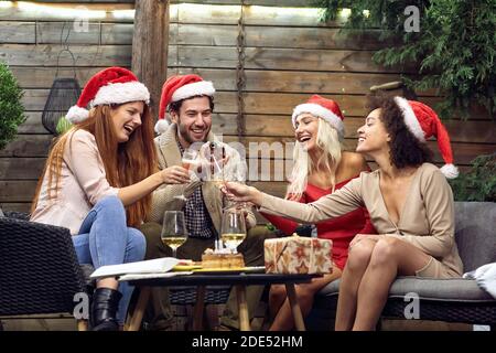 Gruppe von glücklichen jungen Menschen feiern Weihnachten oder Neujahr zusammen; House Party Konzept Stockfoto