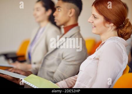 Geschäftsleute hören bei einem Meeting in einer angenehmen Atmosphäre in einem Konferenzsaal aufmerksam zu. Menschen, Arbeit, Unternehmen, Geschäftskonzept. Stockfoto
