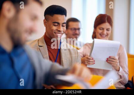 Fröhliche Geschäftsleute bei einem Meeting in angenehmer Atmosphäre in einem Konferenzsaal. Menschen, Arbeit, Unternehmen, Geschäftskonzept. Stockfoto