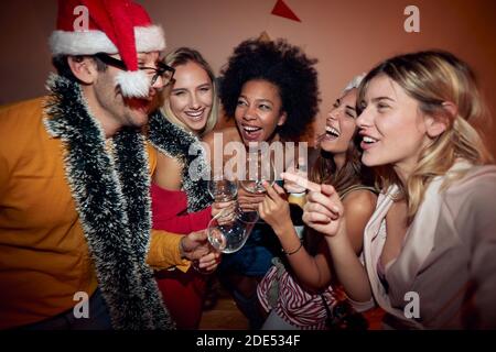 Gruppe von Freundinnen auf Neujahr Party mit einem männlichen Freund, lachen, tanzen Stockfoto