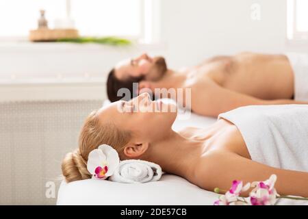 Entspanntes Paar Liegt In Handtücher Gewickelt Während Aromatherapie Entspannung Im Innen Stockfoto