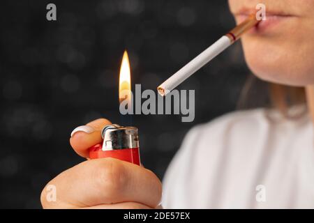 Unkenntlich Frau zündet Zigarette mit Feuerzeug Stockfoto